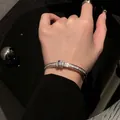 Detailed view of a silver rhinestone geometric bangle bracelet on a female wrist - Small / Silver
