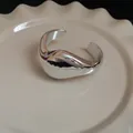 Chunky minimalist irregular geometric silver cuff bracelet displayed on ceramic plate - Silver Twisted Bangle
