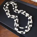Close-up of elegant three-strand French retro pearl necklace on a black display tray - Classic Necklace / White