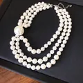 Macro detail of three-strand vintage white pearl necklace featuring elegant large orb pearl - Three Layer Necklace / White