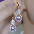 Detailed macro shot of elegant golden hoop earrings featuring zircon and purple pearl - Style 3 Ear Clip