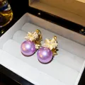 Detail view of purple pearl earrings with zircon flower accents in a grey jewelry box. - 11# Hoop