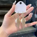 Detailed view of elegant zircon tassel earrings with large white artificial pearls. - 16# Hoop
