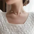 Elegant gold chain necklace featuring white butterfly charms and pearls on a model - Butterfly Rhinestone Necklace