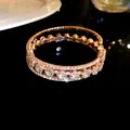Detalle macro de brazalete abierto de tres capas en oro rosa con circonitas - Dorado
