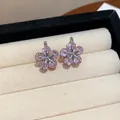 Close-up detail of pink zircon flower-shaped earrings in a jewelry box. - Pink Ear Buckle