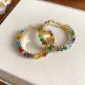 Detailed view of handmade gold hoop earrings wrapped with vibrant colorful crystal beads. - Gold Multicolor