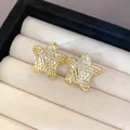 Detailed view of gold-tone star-shaped earrings with unique wrinkled texture in a display case. - Wrinkled Star Style (11)
