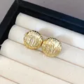 Detail shot of gold ripple textured stud earrings displayed in a luxury cream jewelry box - Wrinkled Round Style (3)