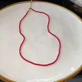 Detail view of a red beaded necklace on a white plate, vintage Chinese style - Red