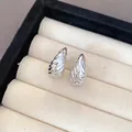 Macro detail of silver-toned pleated teardrop stud earrings in a jewelry box. - Wrinkled Teardrop Style (2)