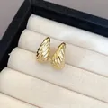 Close-up detail of elegant gold-toned pleated ribbed water-drop earrings in a display box - Wrinkled Teardrop Style (1)