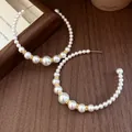 Vista dettagliata di orecchini a cerchio a forma di C con perle bianche graduate - Perno in argento-Bianco