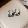 Elegant leopard print enamel hoop earrings in silver-tone finish on a jewelry box - Leopard Print (HE28660) / Silver