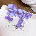 Détail d'élégantes boucles d'oreilles fleurs en tulle violet avec perles et cristaux. - Style / Violet