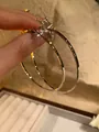Detailed macro view of large minimalist silver oval hoop earrings held by a hand in soft light - Large Oval Hoop Style (38) / Diameter 60mm / Silver