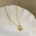 Close-up of a gold-plated horse pendant necklace with sparkling zircons on a white tray - Gold