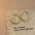 Minimalist gold-toned oval hoop earrings displayed on vintage textured paper background - Small / Simple Oval Hoop Style (52#) / Gold