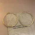 Minimalist gold hoop earrings with silver needle shown on textured paper - Large Smooth Hoop (55#) / Large / Gold