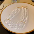 Elegant four-strand white pearl necklace with gold-toned hardware and adjustable clasp - White Quad Layer Style