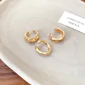Detailed close-up of three irregular textured gold ear cuffs on a ceramic tray - Irregular Round Style / Gold Ear Cuffs (3-Piece Set)