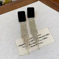 Close-up detail of flocked black square earrings with sparkling long rhinestone tassels - Square Flocked Tassel Style / Gold-Black