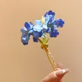 Close-up detail showing a blue fabric flower hair fork with an elegant gold-tone finish. - Hair Stick Gold-Blue / Blue