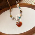 Vintage handcrafted beaded necklace with a resin heart pendant on a rustic wooden tray - Heart Pendant Beaded Style / Coffee