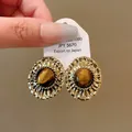 Vintage gold stud earrings featuring a natural tiger eye stone in a retro Maillard style - Wrinkled Metal Oval Stud Style
