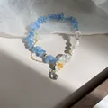Détail rapproché d'un bracelet en pierre bleue avec perles et une breloque fleur - 19# Style Pendentif Fleur Bleue