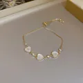 Detailed view of an adjustable gold heart bracelet with white stones and zircons. - Rhinestone Heart Style