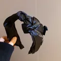Vista dettagliata dell'elegante fascia nera annodata con accenti di catena di cristalli - Fiocco Nero