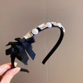 Dettaglio di un cerchietto elegante con perle bianche, cristalli chiari e un fiocco nero chic. - Fiocco piccolo nero