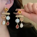 Close-up of French style earrings with pearls and amber gems on a model - 47# Silver Needle - Gold - Champagne