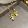 Detailed view of handmade yellow floral earrings with elegant pearls on a gray jewelry tray - Style 5 (Ear Hook)