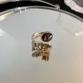 Detailed view of gold-plated ring with square and round zircon crystals on mirror surface - Chocolate Gold
