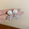 Detailansicht eleganter goldener Perlenohrringe mit schimmernden Kristallherzen - Herz Perle Stil (4#) / Weiß