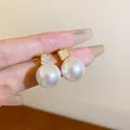 Close-up detail of elegant pearl earrings with square cubic zirconia studs. - Square Pearl (31)