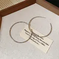Minimalist large silver hoop earrings for women displayed on a rustic canvas background - 5cm / Silver
