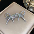 Dettaglio dell'orecchino a clip a forma di fiocco con zirconi cubici scintillanti - Polsino dell'Orecchio (HE30667) / Un paio / Argento