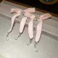 Close-up of pink plush bow earrings with rhinestone snowflakes and pearl drops. - Silver Post Pink Plush Bow (45#)