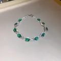 Elegant palace style emerald crystal oval bracelet featuring intricate diamond-set detailing. - Silver