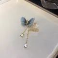 Gros plan d'une broche papillon à franges bleues et glands en zircone raffinée - Broche Bleue