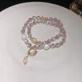 Detailed close-up of double-layered bracelet with cat eye stones, crystals and pearls - Planet Pendant Double Layer Style / Pink