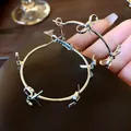 Close-up of silver-colored metal hoop earrings with elegant bowknot details - Bowknot Hoop (HE8275) / Silver