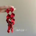 Detailed view of elegant long red petal tassel earrings with gold chains. - 14# Steel Post - Red
