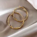 Elegant gold twisted hoop earrings featuring intricate diamond-cut textures and high polish - Mixed Texture (HE8275) / Gold