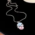Detailed close-up of a silver necklace pendant featuring a blue flower and pink crystal - Silver-Blue-Pink