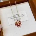 Close-up of an 18k gold-plated firework pendant necklace adorned with sparkling zircons. - Necklace / Gold-Red (Gold Plated)