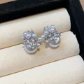 Close-up view of elegant pearl stud earrings featuring a shimmering fireworks zircon cluster - Silver